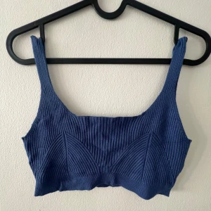 Blå croppad linnetopp från Nelly - Säljer en blå croppad linnetopp från Glamorous (köpt på Nelly). Toppen har breda axelband och fyrkantig ringning, med ribbade detaljer som ger en modern look. Den är bara använd en gång, och har inga skavanker förutom att jag klippt bort plastbanden som man kan använda för att hänga upp den. Nypris 249:-, se mer här: https://nelly.com/se/produkt/glamorous-crop-top_610436-0989/