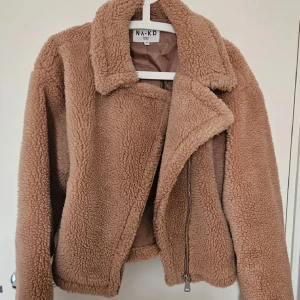 Beige teddyjacka från NA-KD - Supermjuk och fluffig teddyjacka från NA-KD i beige färg. Sparsamt använd så i väldigt fint skick 