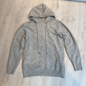 Grå kashmere hoodie  - Mysig grå kashmere hoodie med huva och långa ärmar. Hör av dig vid funderingar 