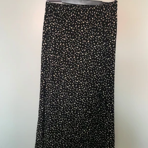 Mönstrad lång omlottkjol - Mönstrad lång omlottkjol från Happy Holly, strl 32/34. Använd några gånger