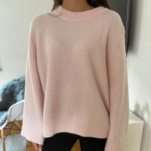 Ljusrosa  stickad tröja - Supermjuk och oversized stickad tröja i ljusrosa med breda ribbade muddar vid ärmslut och nederkant. Perfekt för lager-på-lager och chill dagar. Rund halsringning och långa ärmar ger en avslappnad vibe.