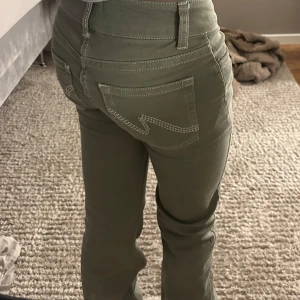 Olivgröna bootcut byxor från Nelly - Snygga olivgröna byxor från Nelly med bootcut passform och låg midja. Endast testade hemma. Inga defekter.🎉💐🥰🙏🏻