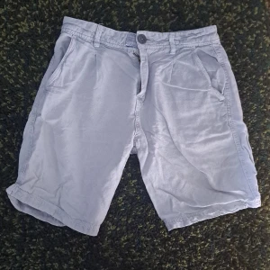 Ljusgrå shorts från Zara, storlek 164 - Snygga ljusgrå shorts från Zara med klassisk passform och midwaist. De har framfickor, bakfickor och bälteshällor. Materialet är mjukt och känns som bomull, perfekt för varma dagar. Stängs med knapp och dragkedja framtill.