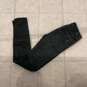 Svarta Replay Hyperflex skinny jeans - Snygga svarta Replay Hyperflex jeans med skinny fit och klassisk femficksdesign. Jeansen har en mörk tvätt och är tillverkade i stretchigt jeansmaterial som sitter tajt och bekvämt. Perfekta för dig som gillar en modern och slimmad look.små i storlekarna