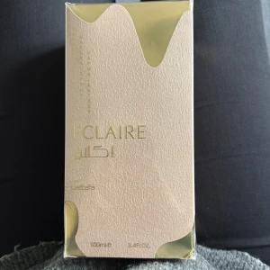 Lattafa Eclaire parfym 100ml - En helt oöppnad lattafa parfym. Lattafa Eclaire är en parfym i en lyxig beige och guldig kartong med elegant struktur. Flaskan rymmer 100 ml och har en exklusiv känsla med gulddetaljer. Perfekt för dig som gillar stilrena och moderna dofter. 