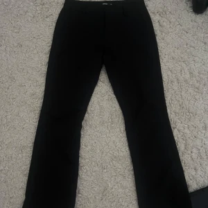 Svarta lågmidjade kostymbyxor från Bik Bok - Snygga svarta lågmidjade kostymbyxor från bikbok som tyvärr är för små i höfterna på mig, använda ett par gånger men inga defekter någon stans! Nypris 499!