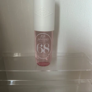 Sol de Janeiro Cheirosa 68 Perfume Mist - Fräsch och trendig parfymmist från Sol de Janeiro, Cheirosa 68. Flaskan är cylinderformad med rosa transparent plast och vit spraykork. Perfekt för dig som gillar söta och blommiga dofter med en modern vibe. Snygg design som passar på hyllan. 90 ml, knappt använd som kan ses på bilderna. 