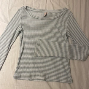 Randig långärmad tröja från Nelly - Supersöt långärmad tröja från Nelly i ljusblått och vitt randigt mönster. Tröjan har en rundad halsringning och är gjord i mjuk bomull med ribbad känsla. Perfekt för en chill och stilren look.