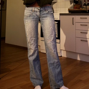 Ljusblå bootcut/raka jeans från Esprit - Säljer ett par ljusblå jeans från Esprit med bootcut passform och slitna detaljer framtill. Jeansen har klassiska fem fickor, låg midja och är tillverkade i mjukt denim. Perfekta för en avslappnad och trendig look.