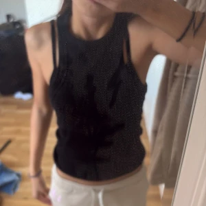 Svart ribbad linnetopp från Gina Tricot - Svart ribbad linnetopp från Gina Tricot, Basically Basics-kollektionen. Toppen är ärmlös med rund halsringning och sitter tight mot kroppen. Perfekt att styla med jeans eller kjol för en clean look.