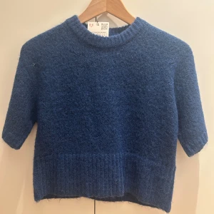 Blå stickad tröja  - Mysig blå stickad tröja med korta ärmar och ribbad kant nertill och vid halsen. Helt oanvänd med prislappen kvar💕 