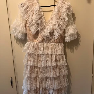 By Malina Sky dress XS - Vit klänning från By Malina i strl XS. Endast använd vit ett tillfälle, som ny. Det enda är att i ena ärmen så har det trådats upp lite, de sista bilden. Syns knappt, då det är lager med tyg i volanger. Nypris: 2800kr