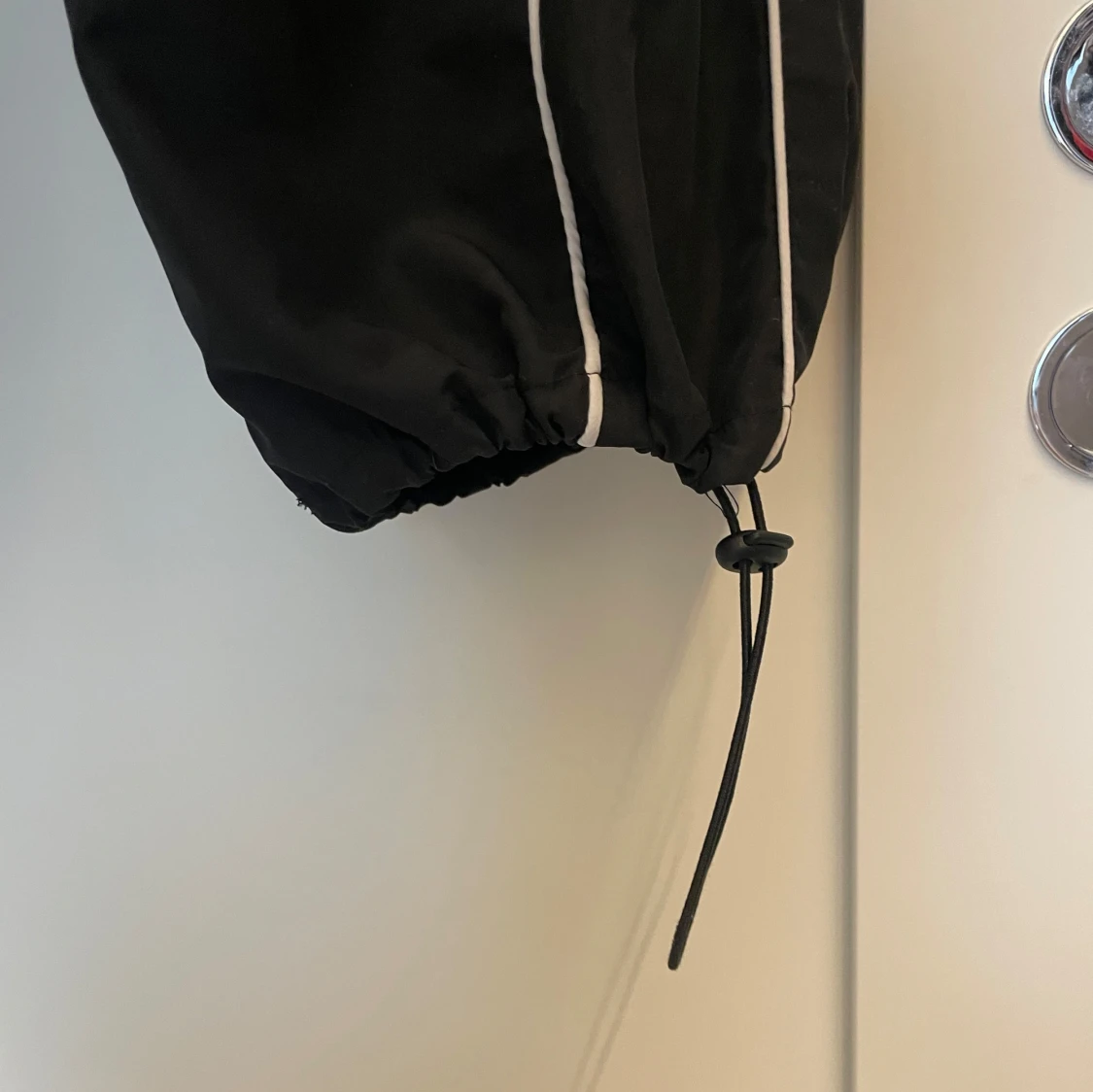 Svarta mjukisbyxor i glansigt material med vita detaljer - 1