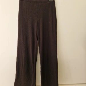 Svarta byxor från Kappahl - Svarta byxor från Kappahl i storlek 146. De har en rak passform med slits vid bensluten och är ribbade i materialet. Ser bruna ut på bilden men som är svarta