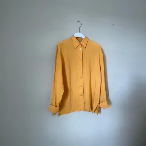 Gul långärmad vintage skjorta från Yessica - Snygg gul skjorta från Yessica i storlek 40. Skjortan har klassisk krage, knappar framtill och långa ärmar med breda manschetter. Materialet känns mjukt och lätt.