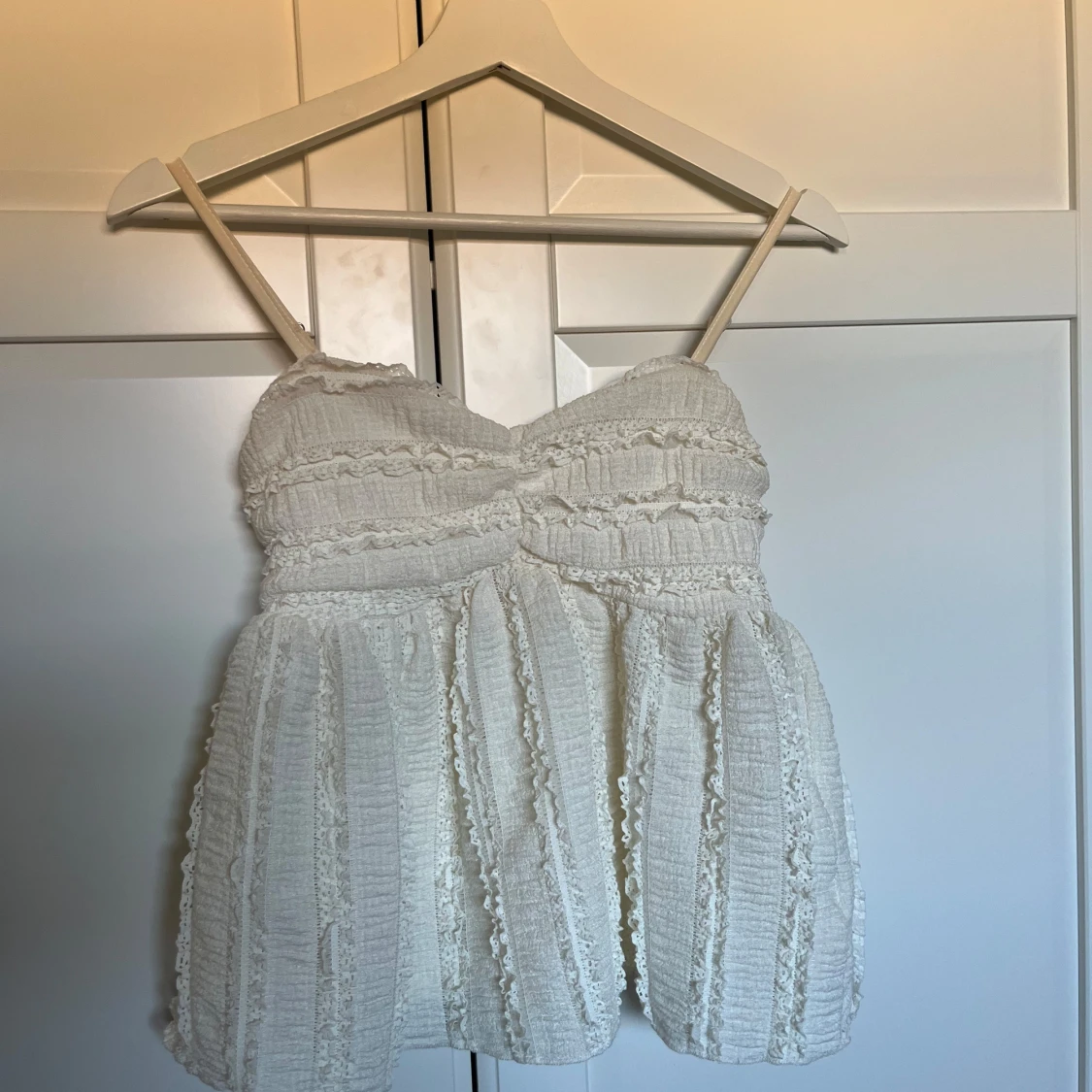 Vit spetsig linnetopp med volanger