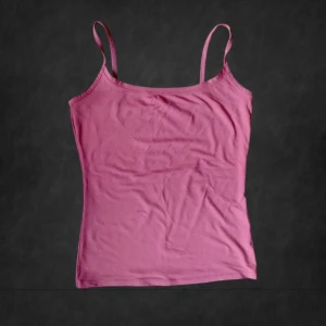 Rosa linnetopp från Intimissimi - Supersnygg rosa linnetopp från Intimissimi med smala axelband och enkel, figurnära passform. Perfekt att styla med jeans eller shorts. Mjuk och skön bomullskänsla som gör den bekväm hela dagen.💕 Lite mer åt det korall rosa hållet.