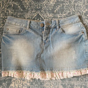 Jeanskjol volang - Så fin jeanskjol med volangkant! Strl 36 o har lite stretch i midjan 💗 midjemått: 37 cm tvärs över men stretchar t ca 40 cm vid behov. Lågmidjad! 31 cm lång (lånade bilder)