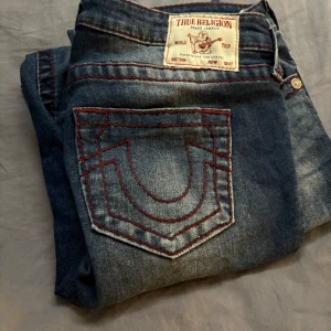 True Religion bootcut jeans med röd söm - Säljer ett par snygga True Religion jeans knappast använda, låg midjade, köpta från Nelly, original pris är 1 199 och dem är ganska nya men priset kan ändå diskuteras 🫶🏼