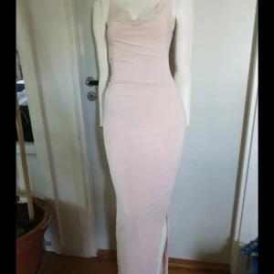 Ljusrosa långklänning med slits - Supersnygg ljusrosa långklänning med smala axelband och draperad halsringning. Klänningen är figurnära och har en slits på sidan för extra vibe. Materialet är mjukt och stretchigt, perfekt för att känna sig både bekväm och chic. Mer bilder på Vinted🥰