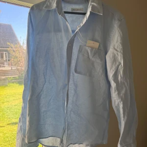 Ljusblå linneskjorta från Zara - Säljer denna superfina linneskjorta i ljusblå! Jag köpte den till min kille men den var tyvärr förliten så därav är den i perfekt skick och aldrig använd!