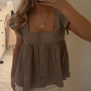 Beige volangtopp - Supersöt beige topp med fyrkantig ringning och knappar framtill, aldrig använd endast testad!☺️💗