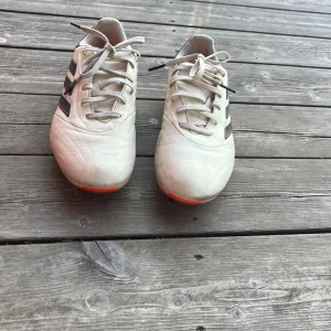 Adidas Copa vita fotbollsskor - Säljer ett par Adidas Copa fotbollsskor i vit med svarta och röda detaljer. Skorna har klassisk snörning, rund tå och platt sula med dobbar för gräsplan. Yttermaterialet är syntet och insidan är mjuk för extra komfort. Perfekt för dig som vill ha stil på planen. Pris kan diskuteras 
