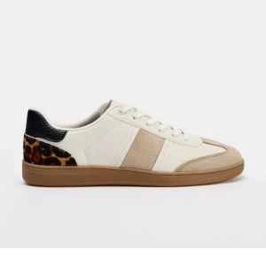 Beige och vita sneakers från Zara - Snygga sneakers från Zara i beige och vitt med detaljer i mocka och skinn. Baksidan har svart skinn och leopardmönster som ger extra edge. Skorna har snörning och platt sula, perfekt för dig som gillar stilrena men ändå unika sneakers. Använda 3 ggr