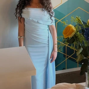 Ljusblå offshoulder långklänning - As snygg baby blå klänning, funkar till både bröllop och andra festligheter. Jättebra skick (som ny) och i storlek S