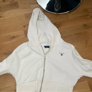 Vit hoodie magtröja från GANT  - tröjan är som en magtröja för den är kort i magen men lång i armarna🤗🤗skriv för bilder eller om ni har frågor!! Jätte snyggt med ett linne under.