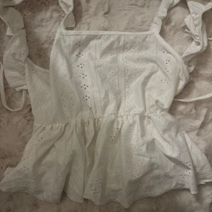 Blus  - Volang armar och knytning i ryggen 