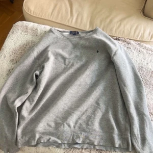 Grå långärmad tröja från Polo Ralph Lauren - Säljer min kompis otrogna psyk ex’s tröja, tyck inte synd om han!! Köp den och var snyggare än honom i den ❤️❤️