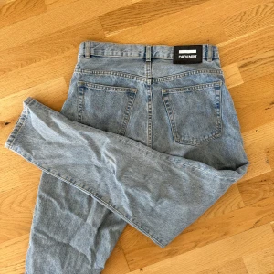 Dr Denim ljusblå high waist jeans - Säljer ett par ljusblå jeans från Dr Denim med klassisk femficksdesign och hög midja. Jeansen har raka ben och är tillverkade i mjukt denimtyg. Perfekt för dig som gillar en chill och tidlös look. Passar till sneakers eller boots. Nora, light retro G81