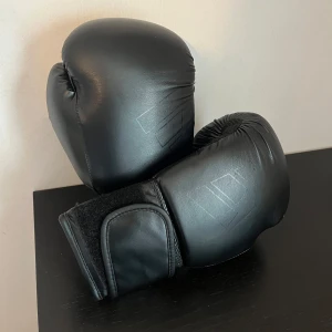 Boxningshandskar Adidas Svarta - Köpte dom för runt 4 månader sen, funkar bra, inga skador!