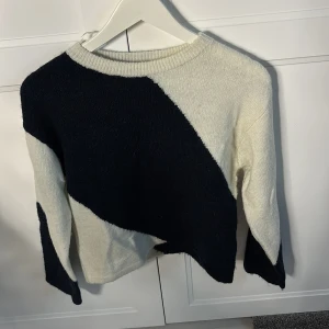 Svartvit stickad tröja Gina Tricot - Snygg stickad tröja från Gina Tricot i storlek 146/152. Tröjan har ett coolt svartvitt mönster med breda diagonala fält och rund hals. Materialet är mjukt och stickat, perfekt för att hålla dig varm under kyliga dagar. Långärmad och passar dig som gillar stilrena kontraster.