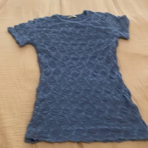 Blå ribbad topp från Zara - Säljer en blå topp från Zara med coolt ribbat mönster över hela tyget. Modellen är kortärmad och har rund hals 💞. 