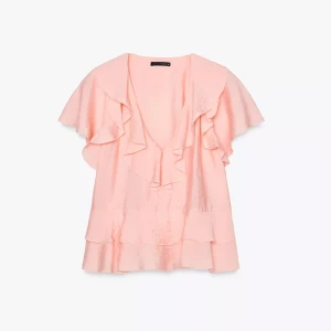 Ljusrosa/aprikos blus med volanger  - Supersöt ljusrosa blus från Zara med v-ringning och stora volanger både fram och bak. Blusen har korta, luftiga ärmar. Helt oanvänd och köptes 1 månad sedan! Slutsåld i Sverige. 