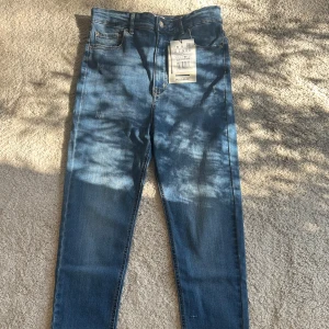 Blå jeans från Pull&Bear - Snygga blå jeans från Pull&Bear i klassisk femficksmodell. Jeansen har en smal passform, normal midja och är tillverkade i stretchigt denim för extra komfort. Perfekt för dig som gillar en stilren look med tajt siluett.