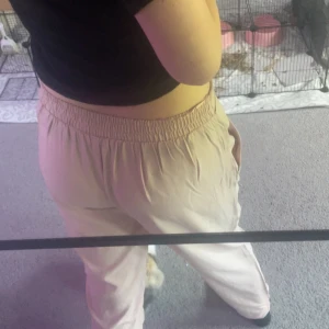 Rosa byxor med bälte från 157 - Säljer ett par rosa byxor från 157 i storlek S. De har elastisk midja, breda ben och ett matchande tygbälte. Materialet är mjukt och flowy, perfekt för chill dagar. Byxorna har fickor och en relaxed passform som ger en skön vibe.