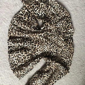 Leopardmönstrad blus från Amisu - Säljer en blus från Amisu med leopardmönster i beige, svart och bruna toner. Klänningen har långa ärmar, snörning framtill och en snygg v-ringad hals. Materialet är mjukt och känns som bomull. Perfekt för dig som vill sticka ut med ett djuriskt print.