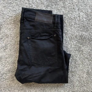 Svarta jeans från Tiger of Sweden - Snygga svarta jeans från Tiger of Sweden i klassisk femficksmodell. Jeansen har raka ben, normal passform och är tillverkade i mjukt bomullstyg med lite stretch. Perfekta för dig som gillar stilrena och tidlösa byxor.