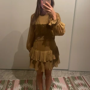 Ljusbrun kortklänning med volang och spetsdetaljer - Säljer denna as snygga klänning pga av att den är för liten för mig💕