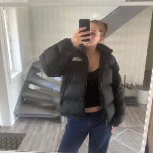  The North Face vinterjacka  - Säljer en svart pufferjacka från The North Face med logga på både bröstet och ryggen. Jag har haft den iallafall två vintrar och köpte den begagnat här på Plick. Det finns skavanker, som hål vid ena fickan. Jag har även ramlat med den när jag åkte moped så det finns skavanker från detta också, inte hål men det är som ytliga rivmärken. Annars ser den bra ut i helhet och värmer en hela vintern. Passar både till killar och tjejer! Jag är 177 till referens och använder M vanligtvis också!🥰