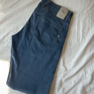 Blå Replay Anbass jeans straight fit - Snygga blå Replay Anbass jeans med klassisk femficksdesign och raka ben. Jeansen har diskreta sömmar på bakfickorna och en liten Replay-logga framtill. Tillverkade i mjukt bomullsmaterial med en skön passform som funkar till allt.