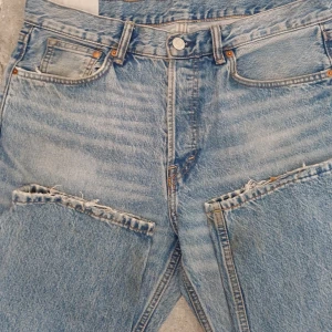 Blå relaxed jeans från H&M 34/32 - Säljer ett par blå relaxed fit jeans från H&M i klassisk tvättad denim. Jeansen har hög midja, raka ben och slitna detaljer vid knäna för en cool, avslappnad look. Perfekta för dig som gillar en loose och bekväm stil.