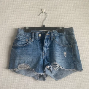 Blå jeansshorts  - Blå jeansshorts från lager 157 med slitna detaljer framtill.