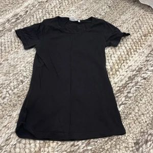 Svart t-shirt S - Enkel svart t-shirt från Tribute i storlek S. Modellen är klassisk med rund halsringning och korta ärmar. 