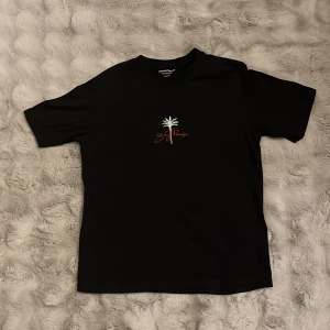 Svart t-shirt Jack & Jones XS - Svart t-shirt från Jack & Jones Originals i bomull med tryck av palmer och texten 'San Francisco' och 'Golden Gate Park' i rött och vitt. Klassisk passform och rund hals. Perfekt för dig som gillar streetstyle och snygga prints. ganska ny och aldrig använt