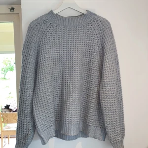 Ljusblå stickad tröja från lager 157 - Mysig ljusgrå stickad tröja från 157 med grov struktur och bred ribbad mudd vid hals, ärmslut och nederkant. 