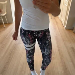 Mönstrade stronger träningsbyxor  - Ett par träningsbyxor med bladmönster i rosa, grått och vitt. Perfekta för träning eller chill. Sitter tight och följer kroppen🏋